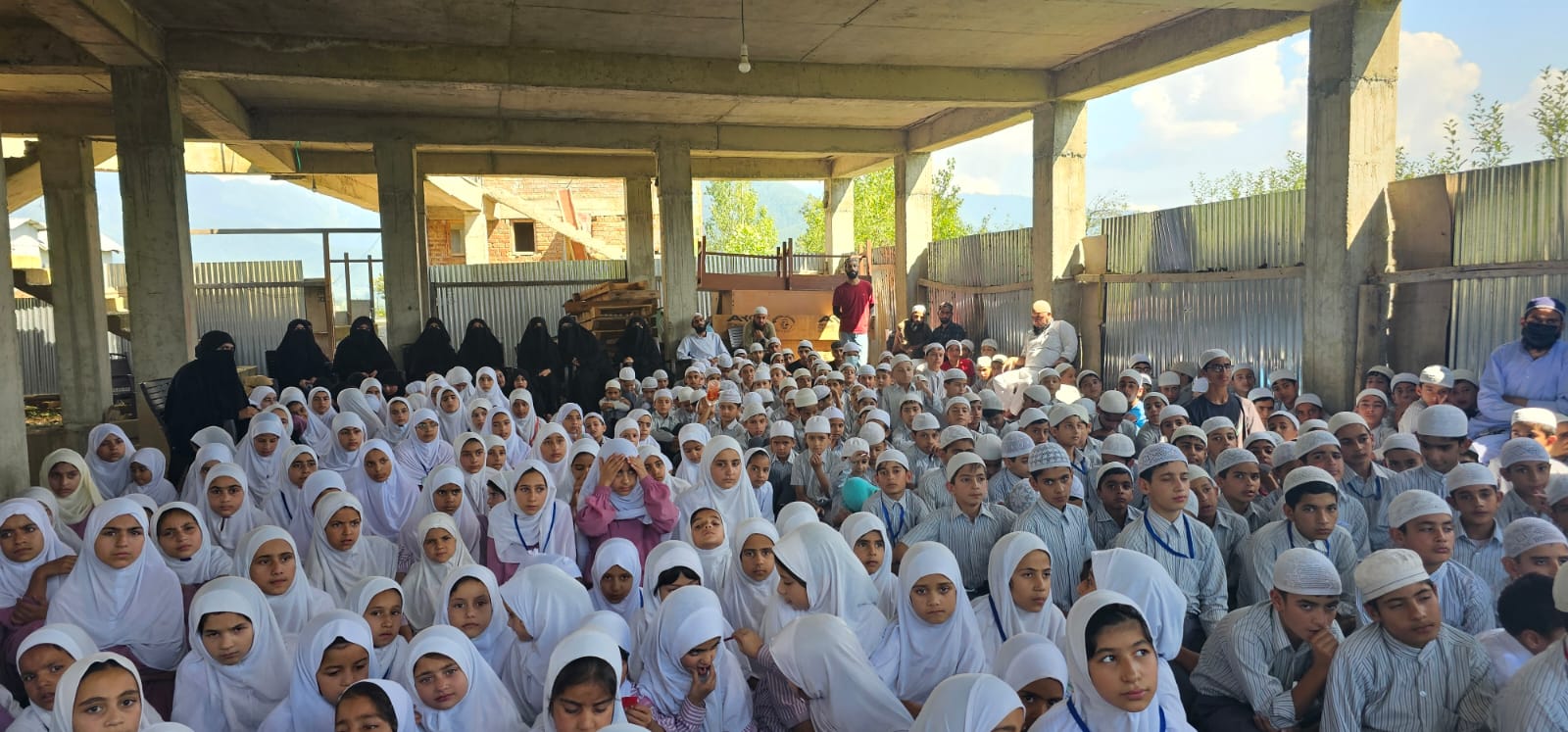 A full-strength morning assembly under the school hall roof.