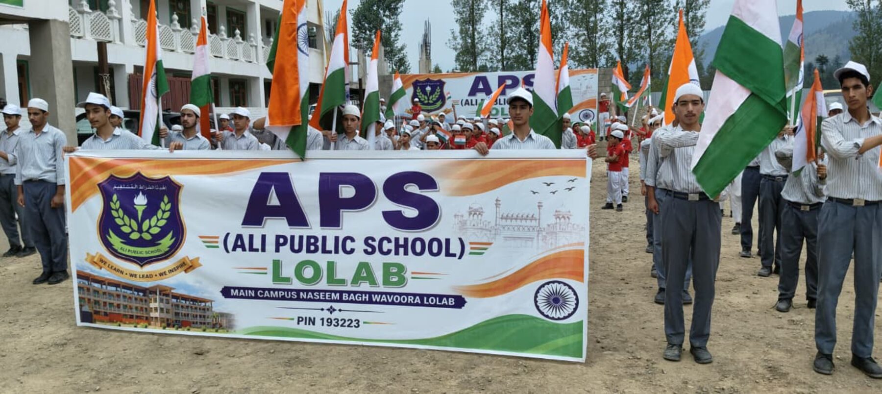 Students holding the APS Lolab banner at a national day celebration.