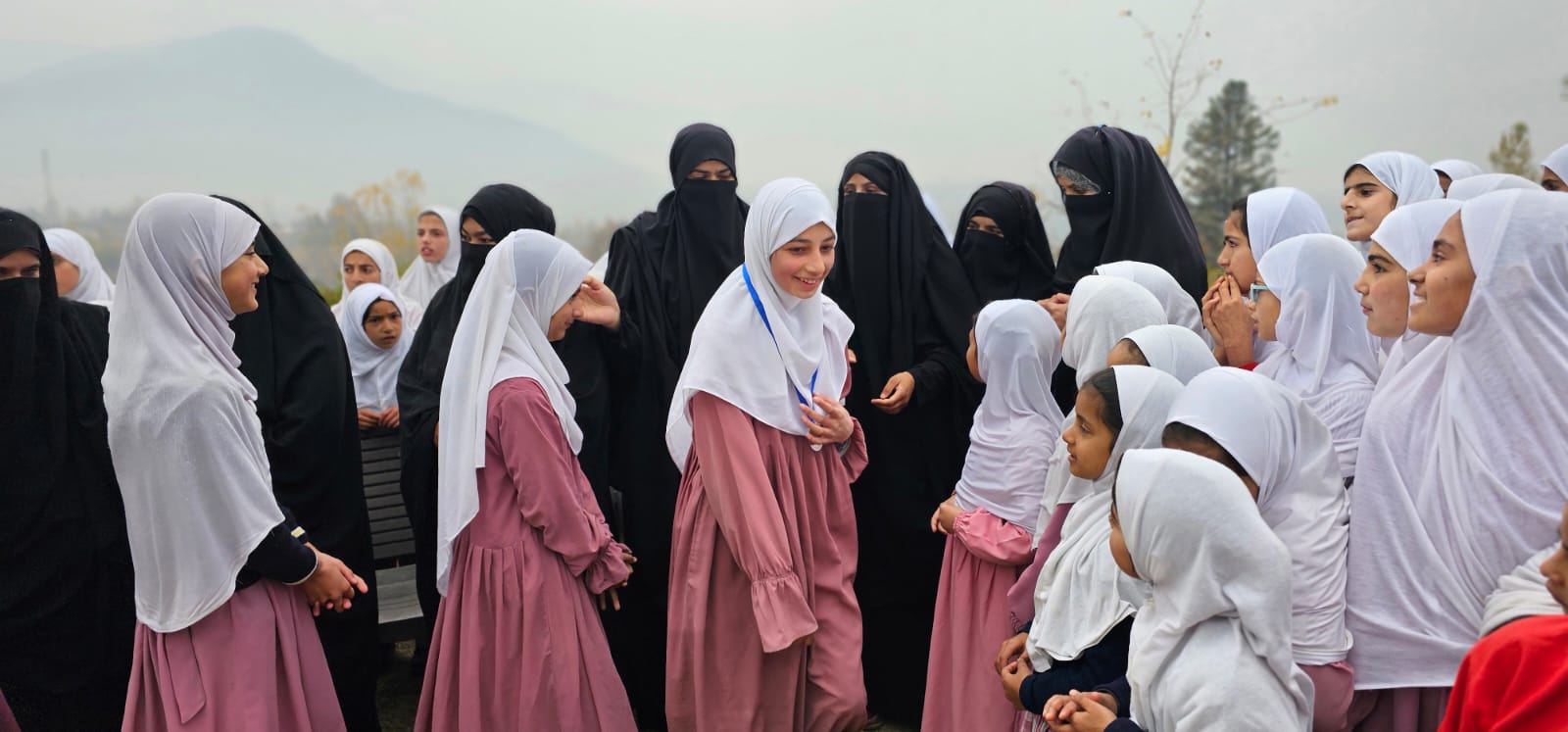 Girls gathered outdoors with their teachers after a school programme.